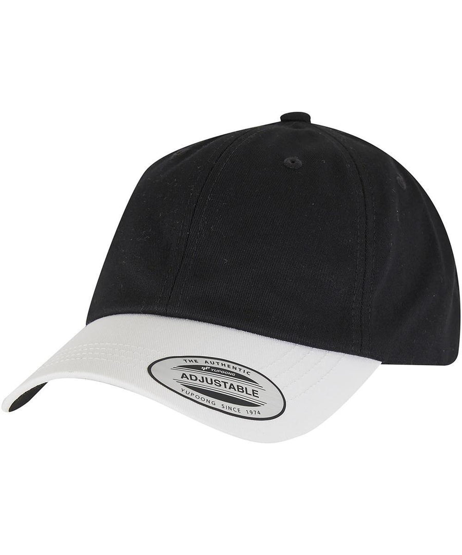 The Flexfit by Yupoong Low-profile cotton twill two-toned (6245CMT) cap features a black crown, white curved brim with a labelled tag, adjustable strap, and top button. Photographed on a white background.